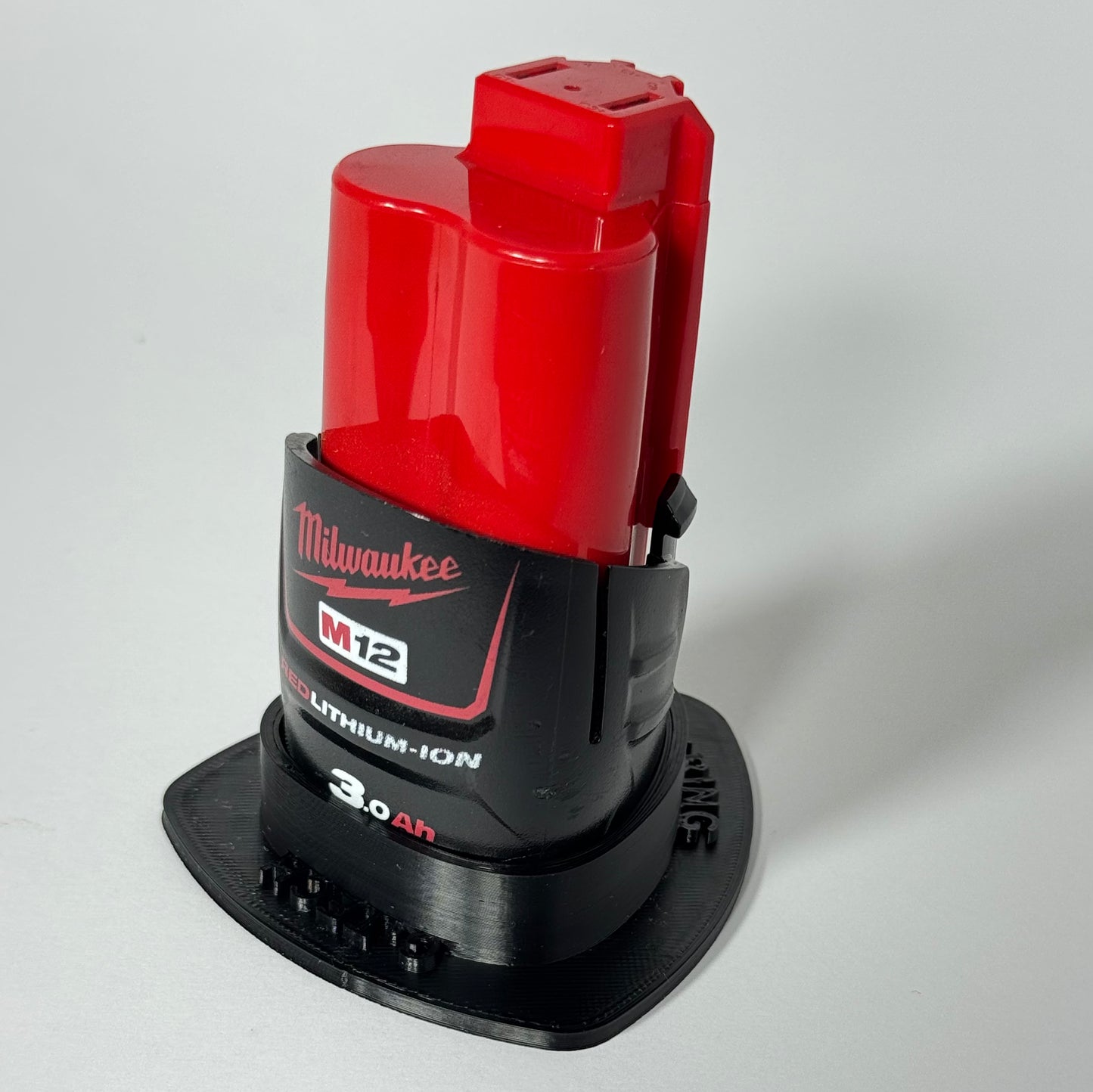 Secure Milwaukee M12 battery storage with a magnetic base, ideal for tool organization on metal surfaces.