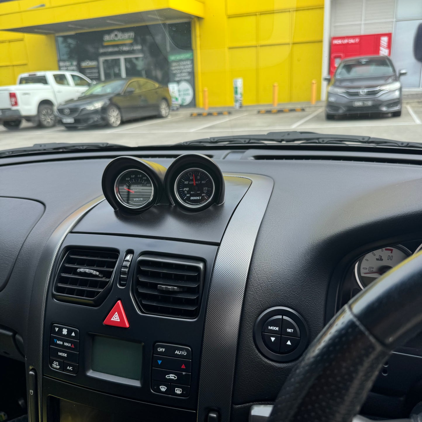 Side angle view from door showing painted satin black VY binnacle gauge pod installed and aligned with dash contours.
