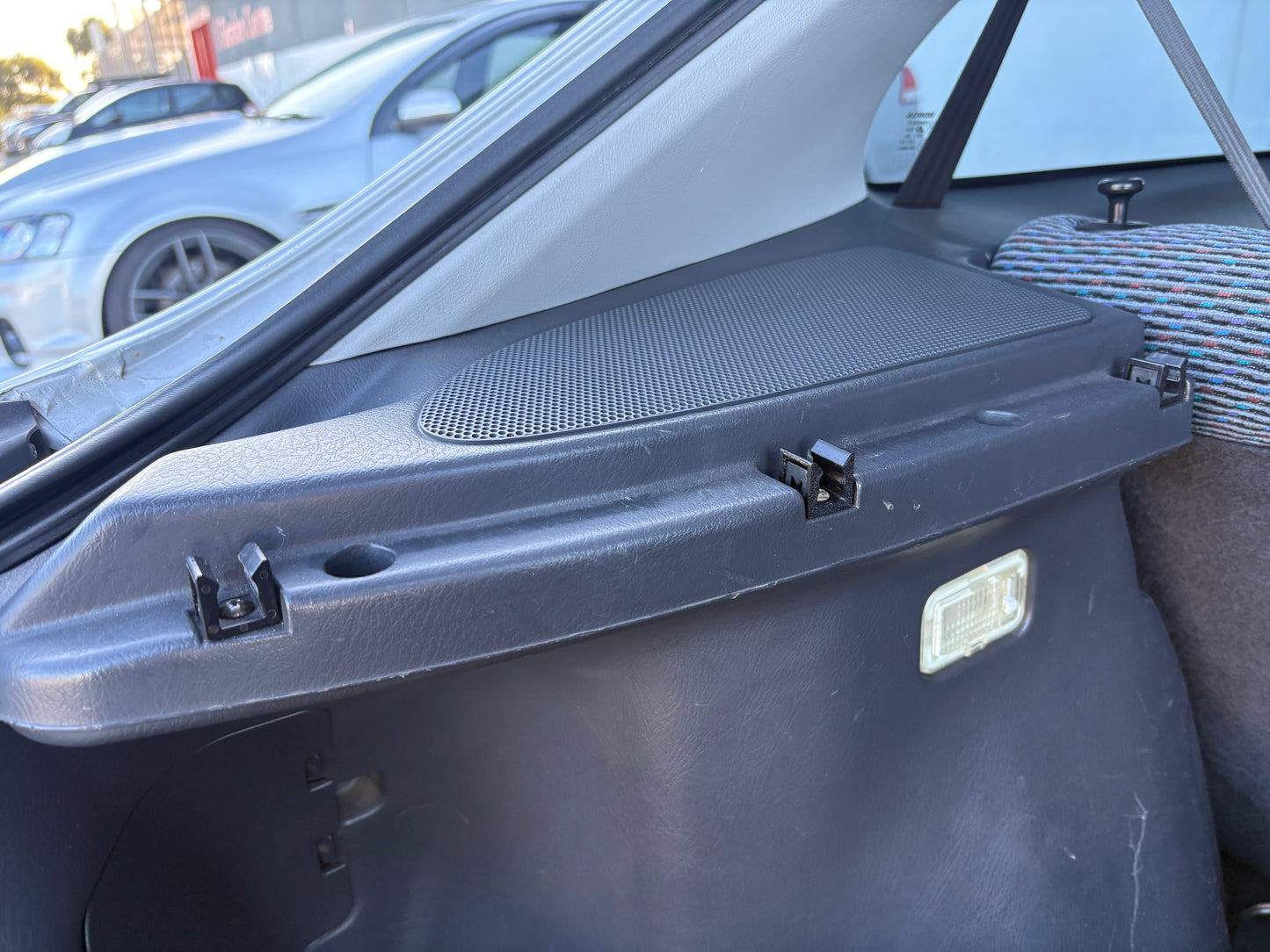 OEM-style parcel shelf clip installed in a 1996–2000 Honda Civic EK hatch, securing the rear tray mount and reducing rattles.