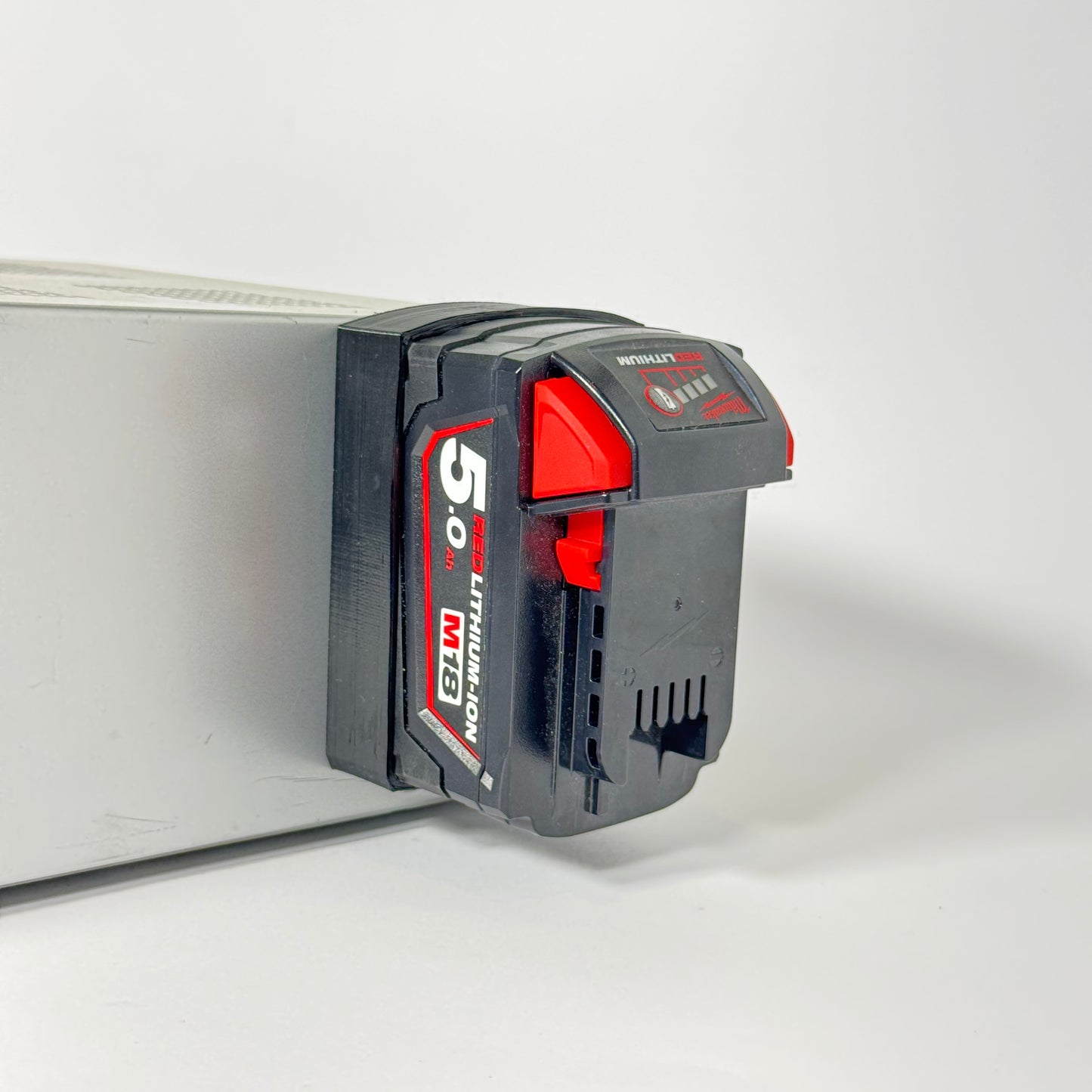 Shatterproof magnetic base for Milwaukee M18 batteries, ideal for mounting tools and organizing your workspace with TPU material.